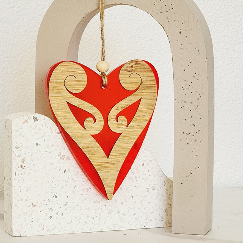 Red satin acrylic heart ornament with intricate koru design, perfect for holiday decor and thoughtful gifting.