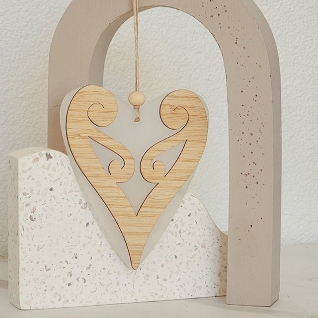 Elegant white satin acrylic heart ornament featuring a delicate Koru design, perfect for modern home decor. 90mm x 105mm.