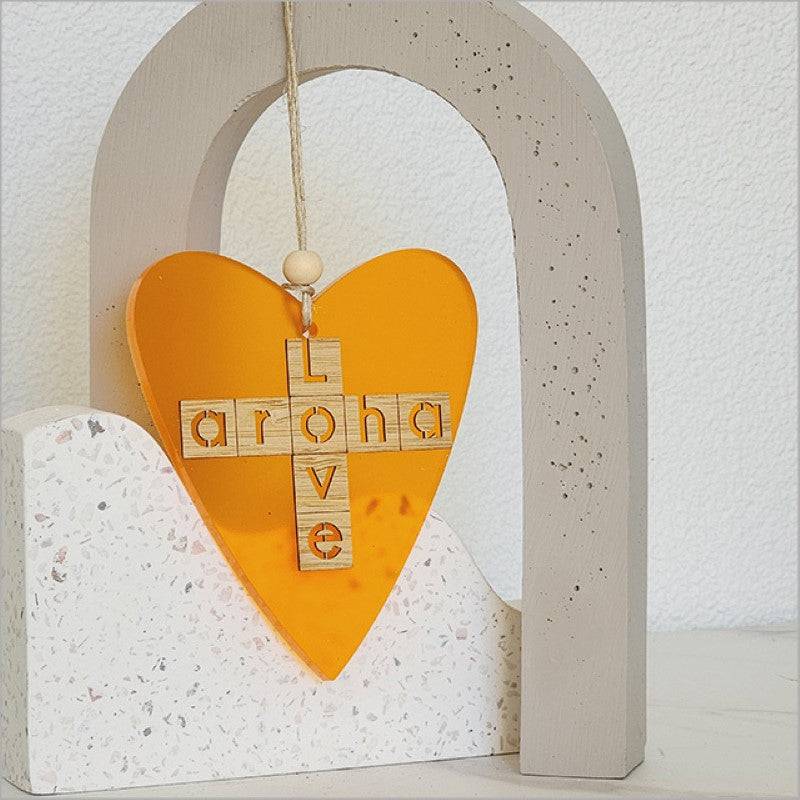 Heart-shaped orange satin acrylic hanging ornament symbolizing love, perfect for gifts and home decor.