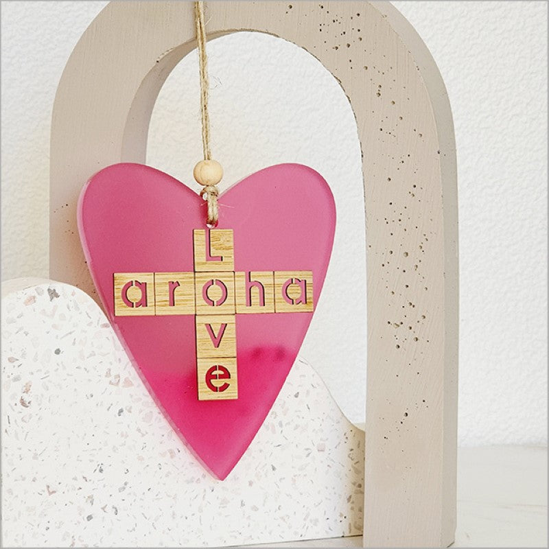 Heart-shaped pink satin acrylic hanging ornament, featuring "Aroha + Love" design, perfect for gifts and home decor.