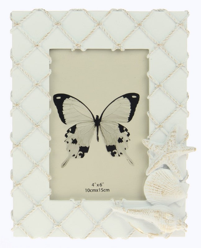 White fishing net frame adorned with seashells, perfect for coastal decor and showcasing cherished beach memories.