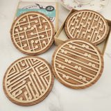 Elegant bamboo and Rimu coasters featuring a koru design, perfect for protecting surfaces while enhancing home decor.