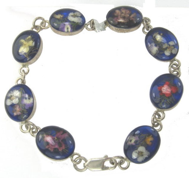 Sterling silver bracelet with multi-colored flowers and navy accents, perfect for adding elegance to any outfit.