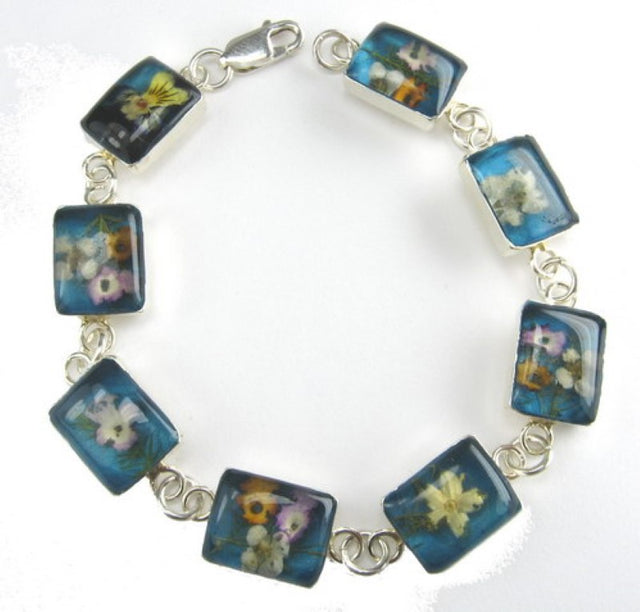 Sterling silver bracelet with square multi-flower design and vibrant turquoise gemstones, perfect for any occasion.