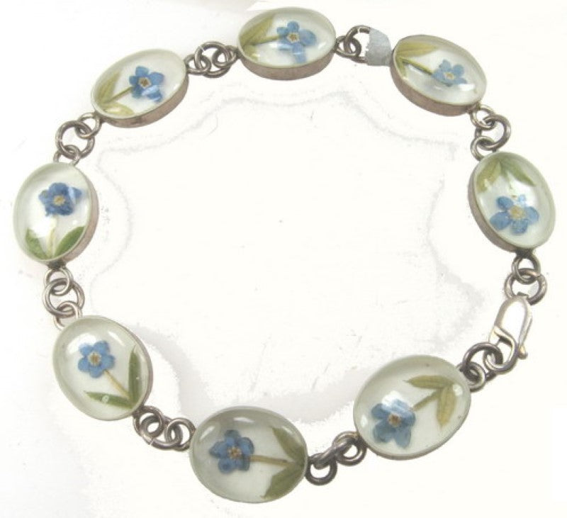 Sterling silver bracelet featuring an oval blue flower design with white accents, perfect for elevating any outfit.