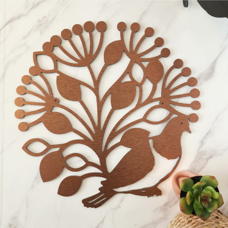 Wall art featuring a Kereru perched in a Pohutukawa tree circle, crafted from brushed copper for indoor and outdoor display.