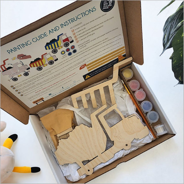 Interactive DIY kit with a wooden dump truck for kids to paint and play, promoting creativity and fine motor skills.