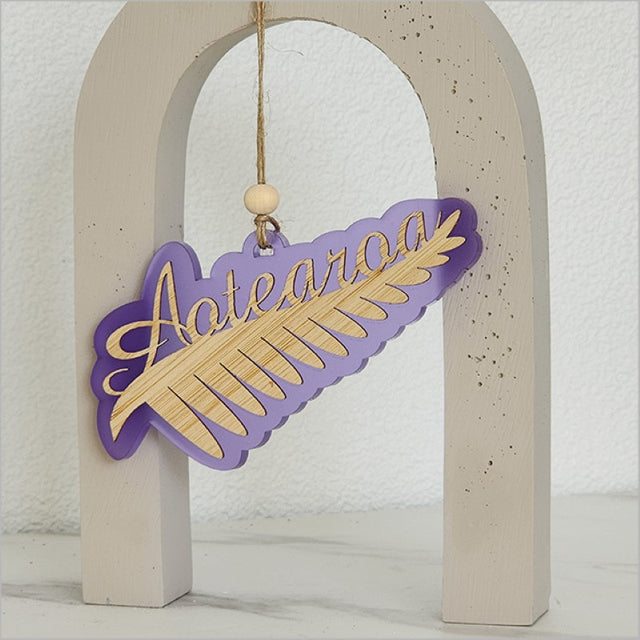 Elegant purple satin acrylic hanging ornament featuring a laser-cut Silver Fern design, perfect for home decor or gifting.