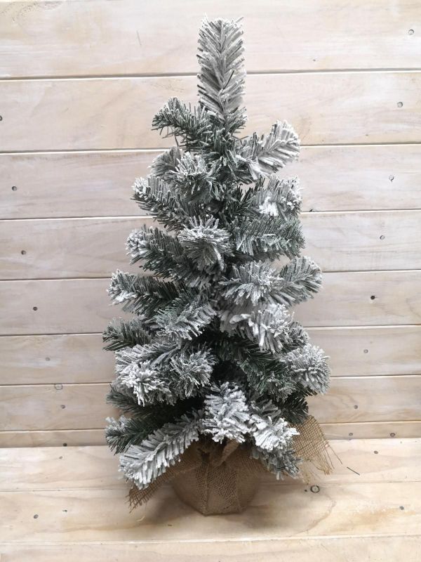 Artificial 24" snowy pine tree with burlap base, perfect for festive decor and hassle-free maintenance.