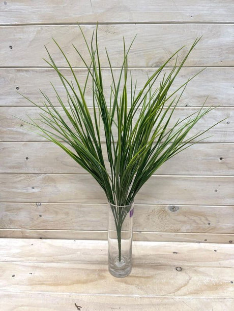 Vibrant green artificial grass bush with long needles, perfect for stylish indoor/outdoor decor without maintenance.