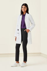 Stylish women's long line lab coat in white, featuring a tailored fit, multiple pockets, and Teflon stain release technology.