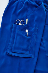 Electric blue slim leg scrub pants with multiple pockets, designed for healthcare professionals in size XXS.