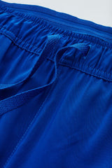 Women's electric blue multi pocket scrub pants in XXS, featuring a tapered leg design and wicking fabric for comfort.