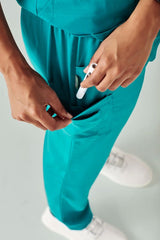 Teal women's scrub pants with straight leg design, multiple pockets, and roll-up option for convenience and style. Size S.