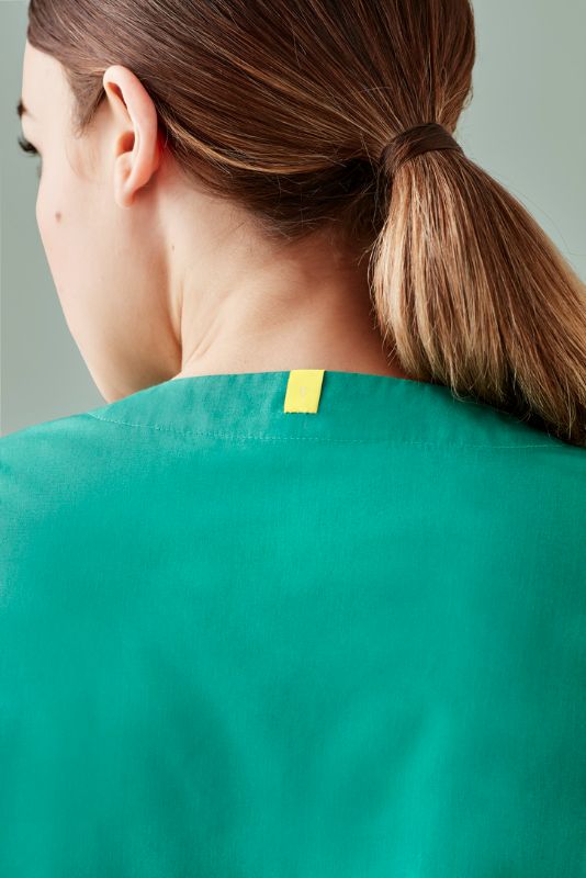 Unisex reversible scrub top in surgical green, featuring chest and back pockets, ideal for healthcare professionals in XXS size.