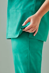 Unisex reversible scrub top in surgical green, featuring pockets, tailored for comfort and style, size XXS.