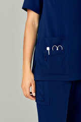 Women's Navy Avery Round Neck Scrub Top from Biz Collection, size Small, featuring multiple pockets and a tailored fit.