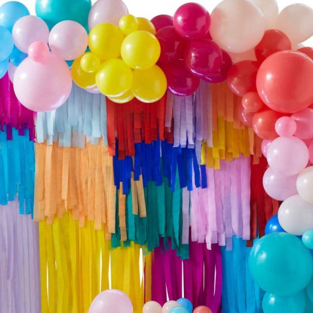 Colorful backdrop kit featuring layered streamers and assorted balloons, ideal for festive celebrations and easy assembly.