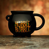 Ceramic cauldron-shaped mug in black, perfect for hot beverages, adds a whimsical touch to any drinkware collection.