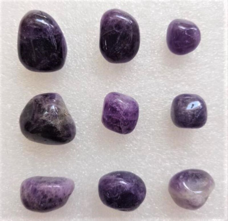 Loose tumbled Amethyst stones in a 0.5KG pack, showcasing enchanting purple hues for decor and spiritual practices.