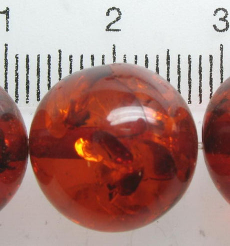 Round amber resin beads, 13mm, in a pack of 30; perfect for jewelry making and crafting with a rich golden hue.