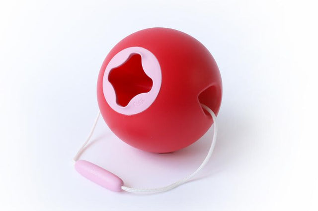 Red Quut Ballo Bucket designed for kids, featuring a stable spherical shape for easy sand and water play without spills.