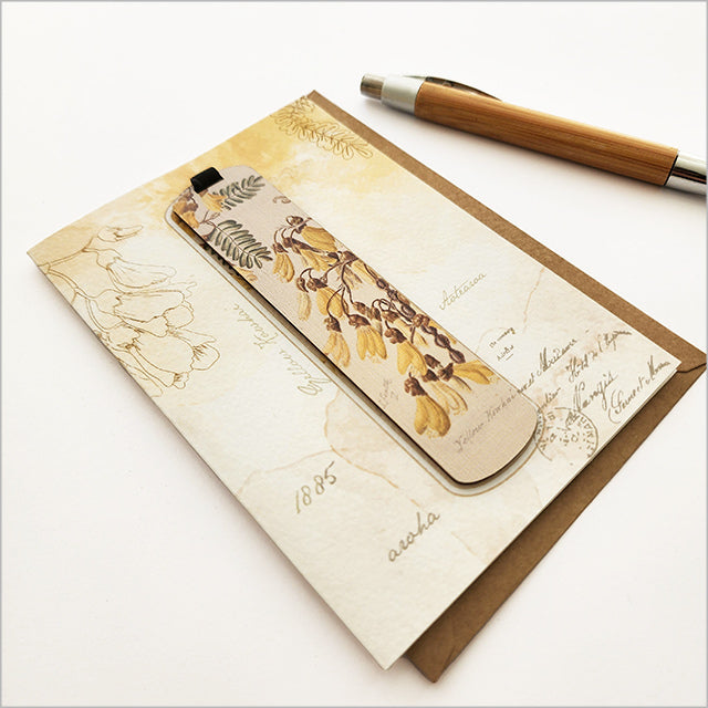 Greeting card featuring vibrant Kowhai flower watercolor art by Sarah Featon, includes a bamboo bookmark with description.