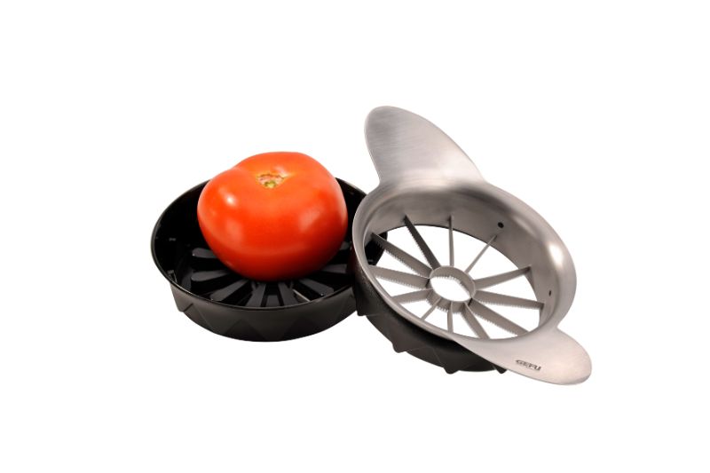 Sleek Gefu Pomo cutter effortlessly slices tomatoes and apples into 12 uniform pieces using a high-grade serrated blade.