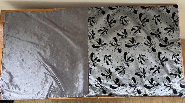 Set of 6 silver cushion covers featuring a black floral design, crafted from soft satinee fabric with a zip closure.