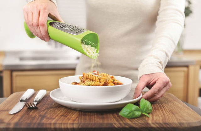 Zeal Tower Grater in vibrant red or green, designed for mess-free cheese grating and easy serving at the table.