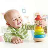 Colorful wooden clown stacker with a curved base for wobbling play, promoting fine motor skills for toddlers 12 months and up.