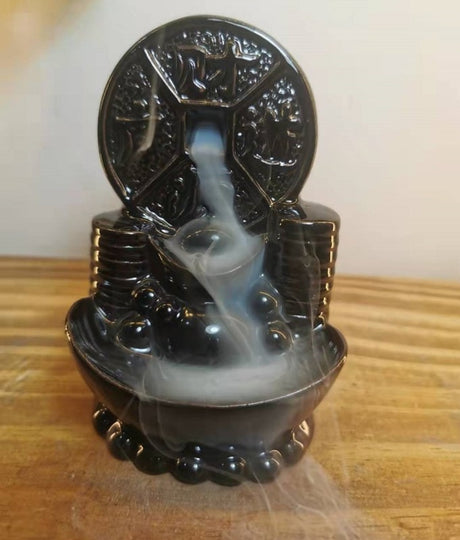 Elegant black ceramic Feng Shui backflow incense burner with cascading smoke effect, enhancing relaxation and ambiance.