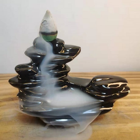 Pebble Stack Backflow Incense Burner in black ceramic, featuring cascading smoke for a serene atmosphere and relaxation.