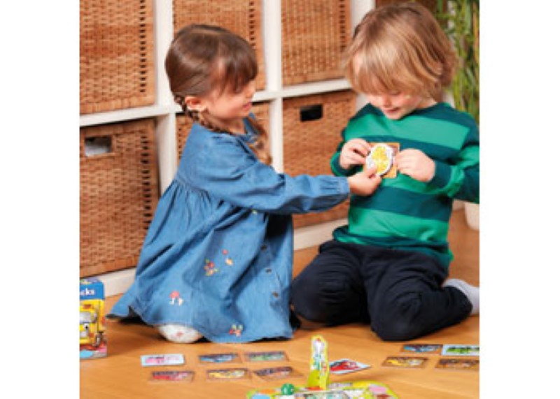 Colorful board game featuring trucks collecting fruit in a muddy adventure, promoting learning and social skills for children.