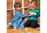 Colorful board game featuring trucks collecting fruit in a muddy adventure, promoting learning and social skills for children.