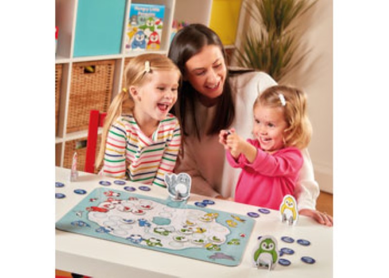 Colorful board game featuring cute penguins collecting fish, promoting fun, strategy, and social skills for kids.