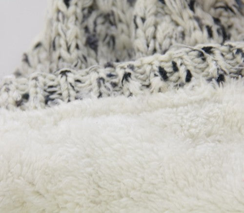 Cream textured beanie with fleece lining, fur pom pom, and cozy 100% acrylic fabric for winter warmth and style.