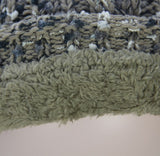 Textured taupe beanie with fleece lining and fur pom pom for warmth and style in cold weather. Perfect winter accessory.