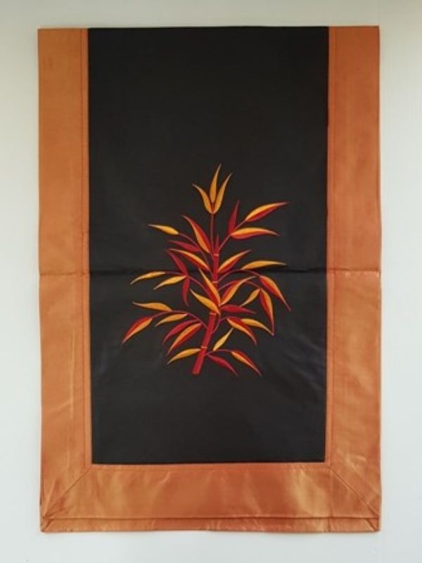 Orange and black fabric and silk table runner featuring elegant bamboo designs, perfect for enhancing dining spaces.