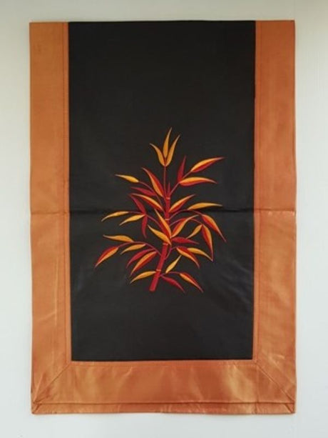 Orange and black fabric and silk table runner featuring elegant bamboo designs, perfect for enhancing dining spaces.