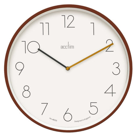 Soft coral wall clock with a clean design and glass lens, perfect for enhancing contemporary home decor.