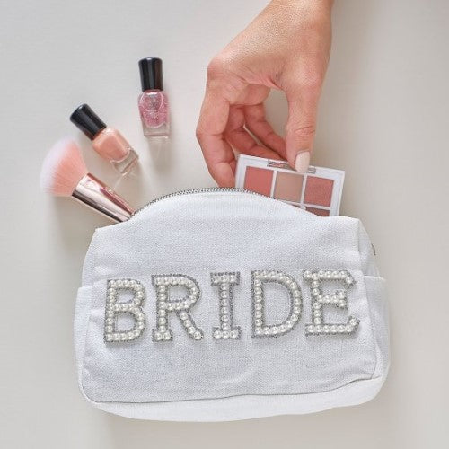 Pearl-embellished white cosmetic bag for brides, stylishly holds beauty essentials with a silver zipper, perfect for hen parties.