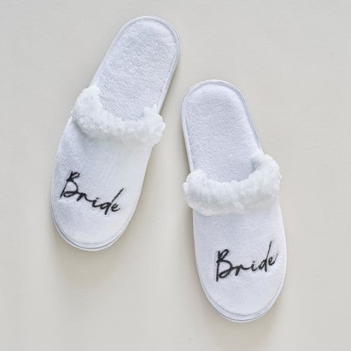 Luxurious white bridal slippers with ‘Bride’ embroidered in black for comfort and style during hen parties.