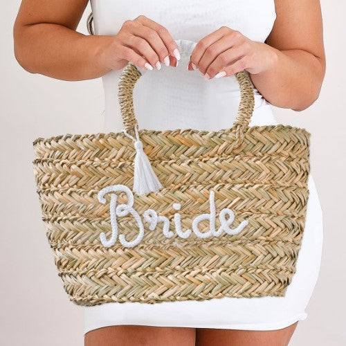 Stylish woven rattan bag for hen parties, featuring 'Bride' lettering and chic white tassels, perfect for carrying essentials.