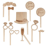 Rustic wooden wedding photo booth props with burnt details, including floral headband, heart glasses, and fun signs.