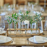 Rustic wood centerpiece with six glass test tubes for elegant floral displays, perfect for events and home decor.