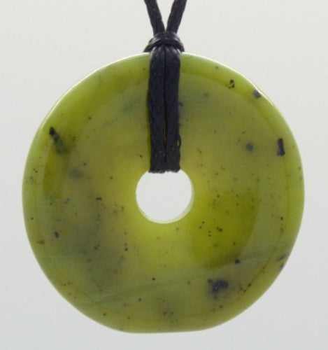 Elegant jade donut pendant, 34mm diameter, on a black adjustable cord, promoting harmony and individuality.