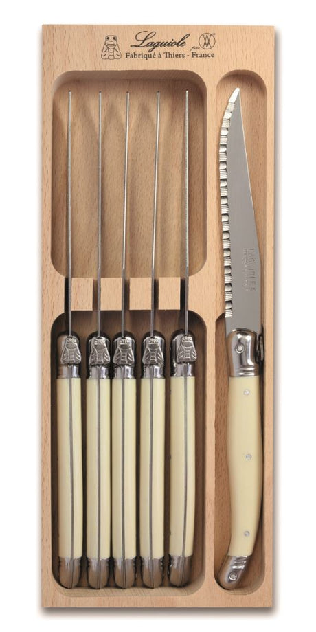 Set of 6 elegant ivory-handled steak knives with stainless steel blades, featuring the iconic Laguiole Bee, presented in a wooden tray.