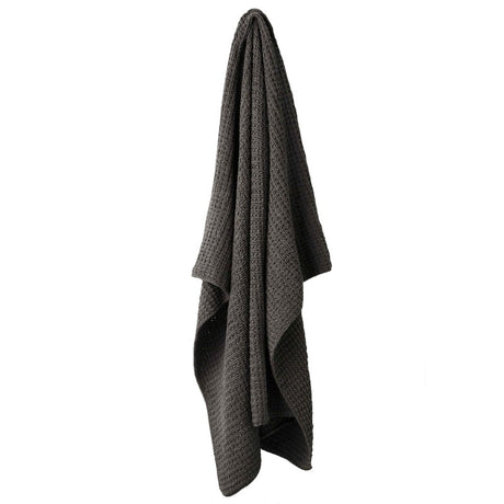 Hand knitted Aura throw in pure cotton, measuring 130x180cm, perfect for cozy warmth and style.