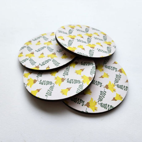 Single Printed Kowhai coaster, 10cm diameter, with vibrant yellow flower design and durable cork base for heat protection.